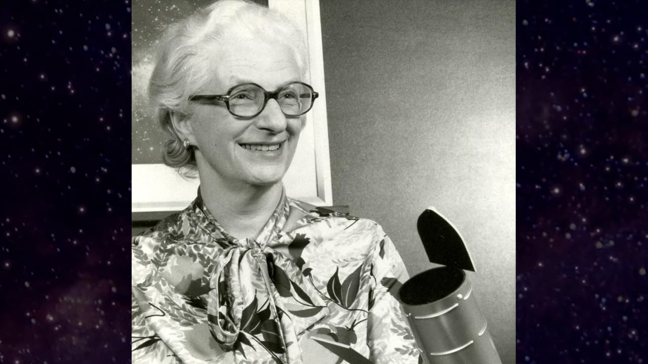 Dr. Nancy Grace Roman poses with a model of the Hubble Space Telescope.